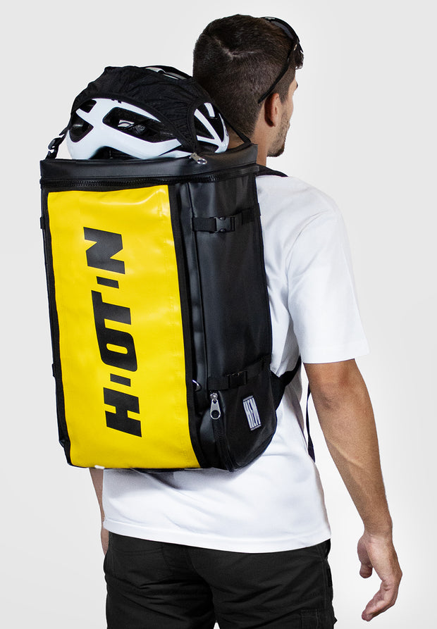 uomo con zaino da trasferta per ciclista giallo e casco fuori